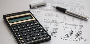 Taschenrechner, Stift und Belege zur Veranschaulichung von Rundungsdifferenzen in Mehrwertsteuerlisten